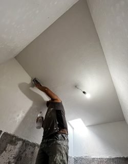 Construction worker repairing the walls of a house.