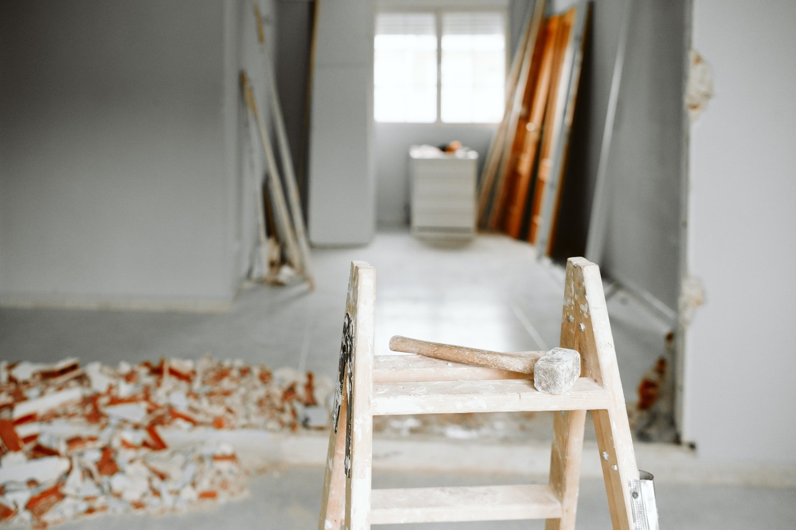 ladder, hammer and debris at home construction site. Home renovation ladder, hammer and debris at home construction site. Home renovation